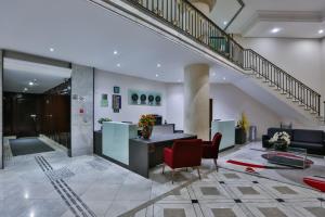 a lobby with a staircase and a red chair at Transamerica Paradise Garden in Sao Paulo