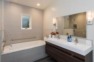 a bathroom with a tub, sink and mirror at Olea Hotel in Glen Ellen
