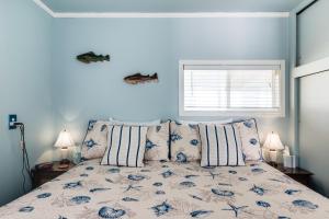 a bedroom with a bed with blue walls and a window at Kiwi's Cottage in Gleneden Beach