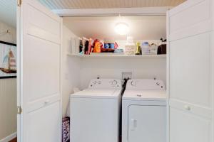 a laundry room with white cabinets and a washer and dryer at Wendell K. Backus House in Cotuit