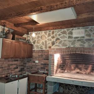 eine Küche mit einem gemauerten Kamin und einem Waschbecken in der Unterkunft Apartments"Nika" with private pool in Galovac