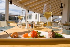 a plate of food on a table with wine glasses at Ganimede Hotel in Sperlonga