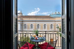 a balcony with a table and chairs and a building at Noma Hotel in Athens