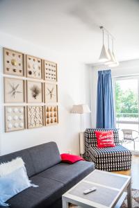 a living room with a couch and a chair at APARTAMENT SEASHELL KOŁOBRZEG BOCIANIE GNIAZDO in Kołobrzeg