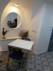 uma mesa e cadeira num quarto com um espelho em בבית של סבתא וסבא em Safed