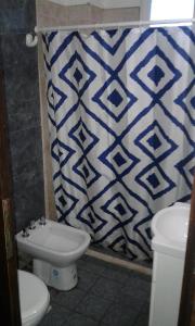 baño con aseo y cortina de ducha azul y blanco en Apart Altos Del Bolson en El Bolsón