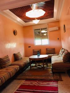 a living room with two couches and a table at Elmenzah Apartments in Taroudant