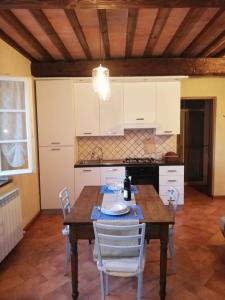 kuchnia z drewnianym stołem i białymi szafkami w obiekcie Casa Rigoletta w mieście Lari