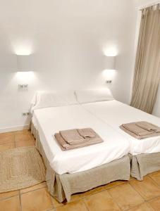 Una cama blanca con toallas en una habitación en Apartment Boutique Hort, en Cadaqués