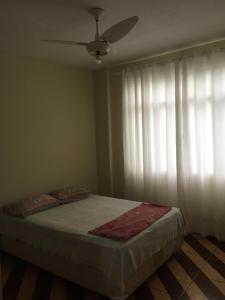 um quarto com uma cama e uma ventoinha de tecto em Apartamento Confortável na Zona Norte no Rio de Janeiro