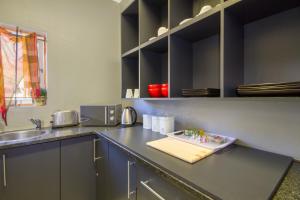 uma cozinha com uma bancada com um lavatório e uma bancada com um sidx em The Minimalist Studio B em Benoni