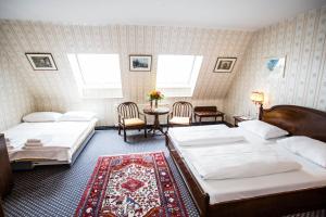 um quarto com 2 camas, uma mesa e cadeiras em Hotel Atlanta em Viena