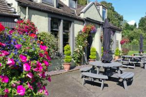 a patio with benches and flowers in front of a house at Auld Mill House Hotel in Dunfermline