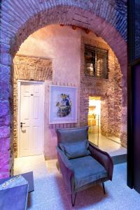 a chair in a room with a brick wall at Noma Hotel in Athens