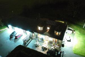 an aerial view of a house at night with cars parked in front at Auld Mill House Hotel in Dunfermline