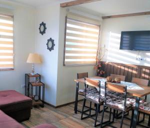 a dining room with a table and chairs and windows at Cabañas Cerro Zapata in Puerto Natales
