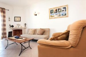 a living room with a couch and a coffee table at Os Apartamentos A Ramos na Praia da Galé Estão inserido em Condomínio com PISCINA, Fica apenas a 350 Metros da Praia da Galé - Apartamentos com Ar Condicionado tanto nos Quartos como na Sala, Smart TV com Prime Vídeo e Cozinha Completa in Albufeira