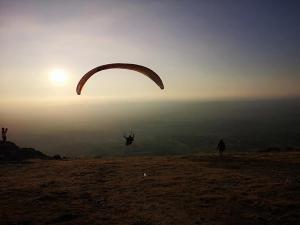 una persona volando un paracaídas en la cima de una colina en Terra Mista Alojamento Local, en Gouveia