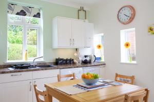 Una cocina con una mesa con un bol de fruta encima. en Little Coombe, en St Ives