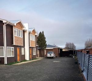 a car parked in a parking lot between two houses at Cabañas Cerro Zapata in Puerto Natales