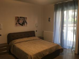 1 dormitorio con cama y ventana en Le Divine di via Olivieri - Reception Via XXV Aprile 5 en Levanto