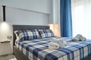 a blue and white bed with towels on it at CasaMeo in Marsala