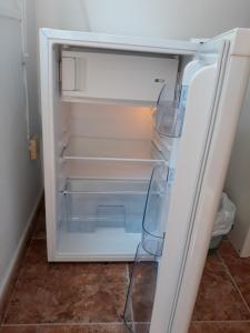 an empty refrigerator with its door open in a room at El patio de Villa Pancho in Chipiona
