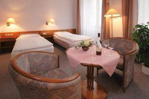 ルハチョヴィツェにあるDům Bedřicha Smetanyのベッド2台、テーブルと椅子が備わるホテルルームです。