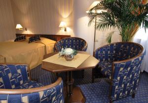 a hotel room with two beds and a table and chairs at Dům Bedřicha Smetany in Luhačovice