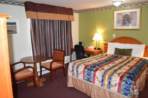 a hotel room with a bed and a table at Lincoln Motel in Sturgeon Falls