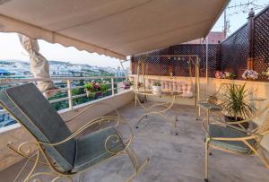 a balcony with chairs and a table on a roof at Top Floor Studio Near Metro&View in Athens