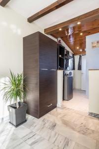 a kitchen with a large wooden cabinet and a potted plant at Top Floor Studio Near Metro&View&200mbps in Athens
