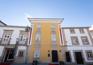un gran edificio amarillo con edificios blancos en Casa Amarela TH & National Monument, en Castelo de Vide