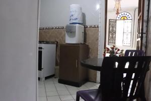 a small kitchen with a table and a microwave at Casa da Josi - Pajuçara in Maceió