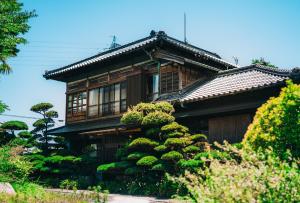 una casa con un arbusto delante de ella en Kacho-en / Vacation STAY 1048, en Mitoyo