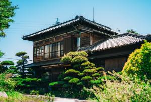 ein Haus mit einem Busch davor in der Unterkunft Kacho-en / Vacation STAY 1048 in Mitoyo