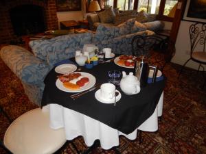 a table with plates of food on it in a living room at Montville Boutique BnB in Montville
