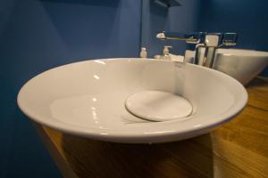a white sink with a toilet in a bathroom at ZIGZAG HOSTEL in Praia da Vitória