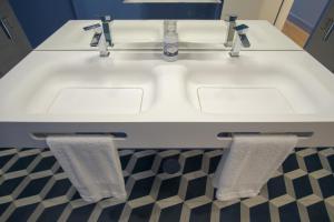 a bathroom sink with two towels hanging on it at ZIGZAG HOSTEL in Praia da Vitória