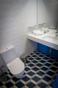 a bathroom with a white toilet and a sink at ZIGZAG HOSTEL in Praia da Vitória