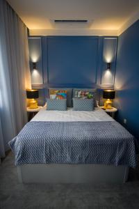 a bedroom with a large bed with a blue wall at ZIGZAG HOSTEL in Praia da Vitória