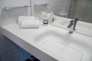 a bathroom counter with a sink and a mirror at ZIGZAG HOSTEL in Praia da Vitória