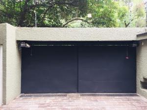 a large black garage door on a building at Beautiful apartment Ahuehuetes in Mexico City