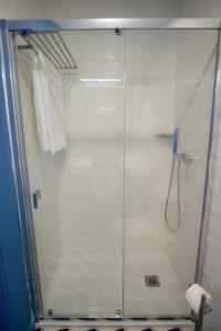 a shower with a glass door in a bathroom at ZIGZAG HOSTEL in Praia da Vitória