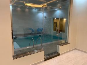 a swimming pool with a glass shower in a bathroom at Violette Chalet in Abha