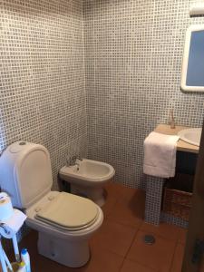 a bathroom with a toilet and a sink at Casa de Lá in Prainha de Cima