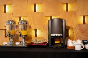 una cafetera sentada en una mesa junto a una cafetera en The Quadrant Hotel & Suites, en Auckland