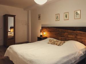a bedroom with a white bed with a wooden headboard at Martinkovice 201 Broumov in Martínkovice