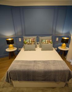 a bedroom with a bed with two lamps on two tables at ZIGZAG HOSTEL in Praia da Vitória