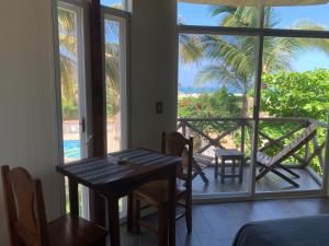 a room with a table and chairs and a balcony at Playa Bruja Zicatela in Puerto Escondido